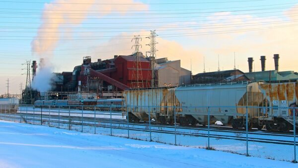 A steel plant with smokestacks and rail cars beside snow on the Cuyahoga River in Cleveland