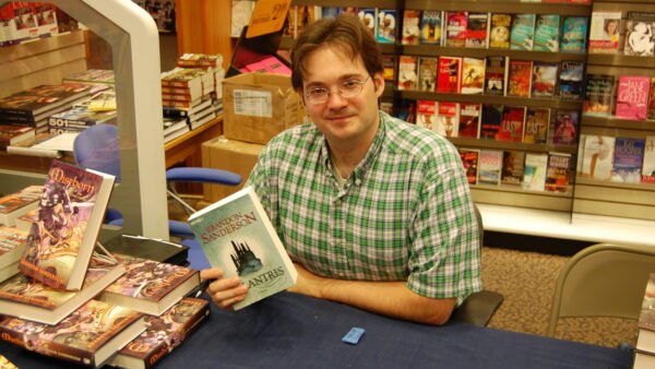 Brandon Sanderson holding a copy of his novel Elantris