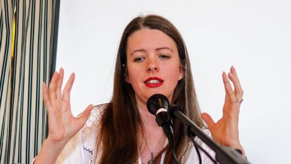 Author Emma Newman speaking into a microphone on a convention panel