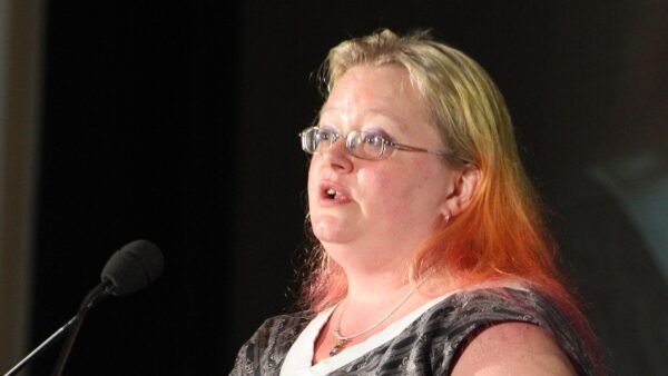 Author Seanan McGuire speaking at a microphone on stage